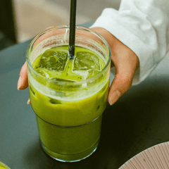 Foto segelas es matcha hijau dengan es batu dan sedotan hitam